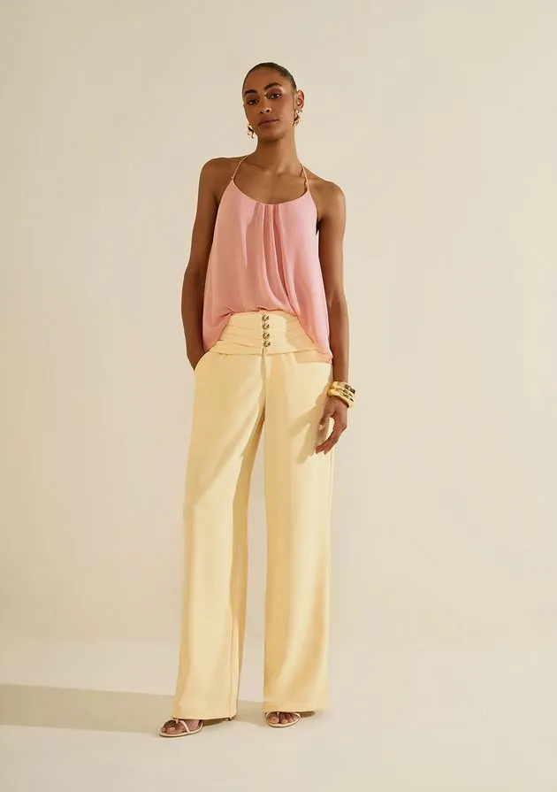 Modelo usando calça pantalona amarelo-claro com blusa rosa